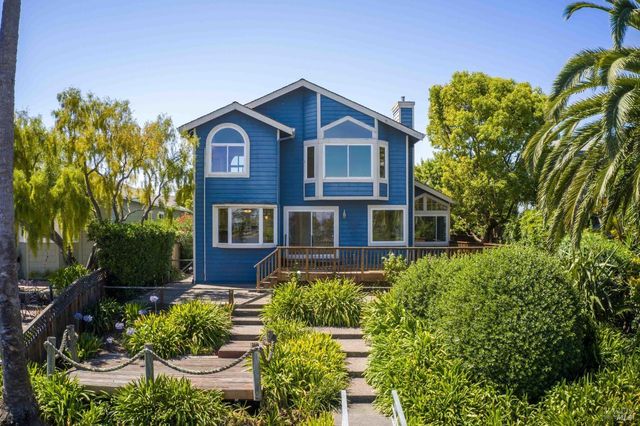 a front view of a house with a yard and outdoor seating
