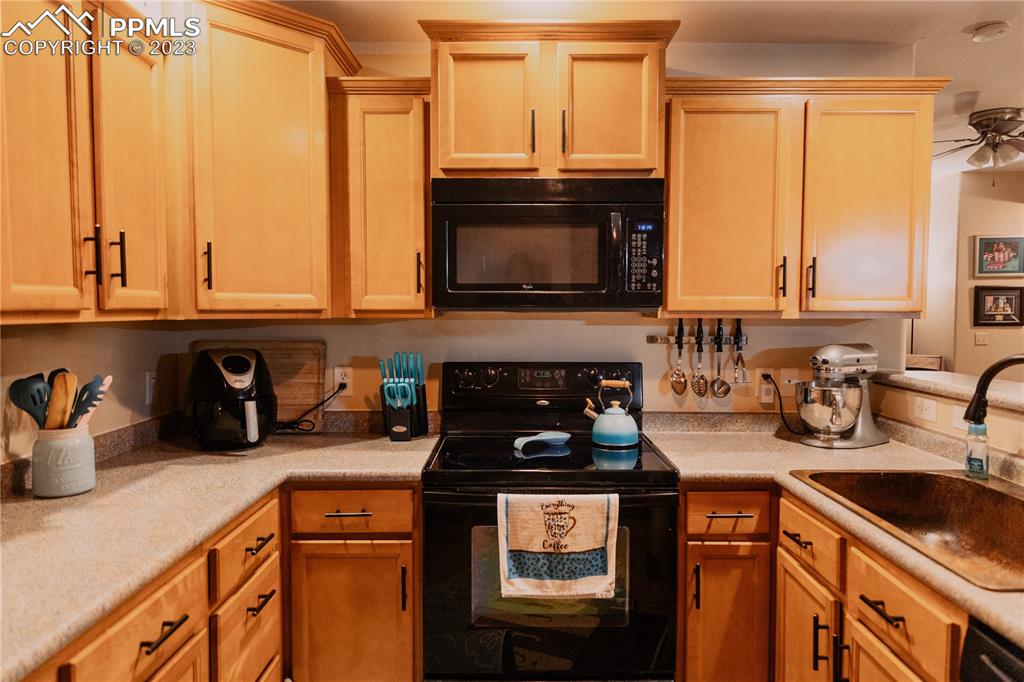 4848 Kerry Lynn View, Unit 202 Colorado Springs, CO 80922 - Photo 7 of 14 a kitchen with a stove a sink and a microwave