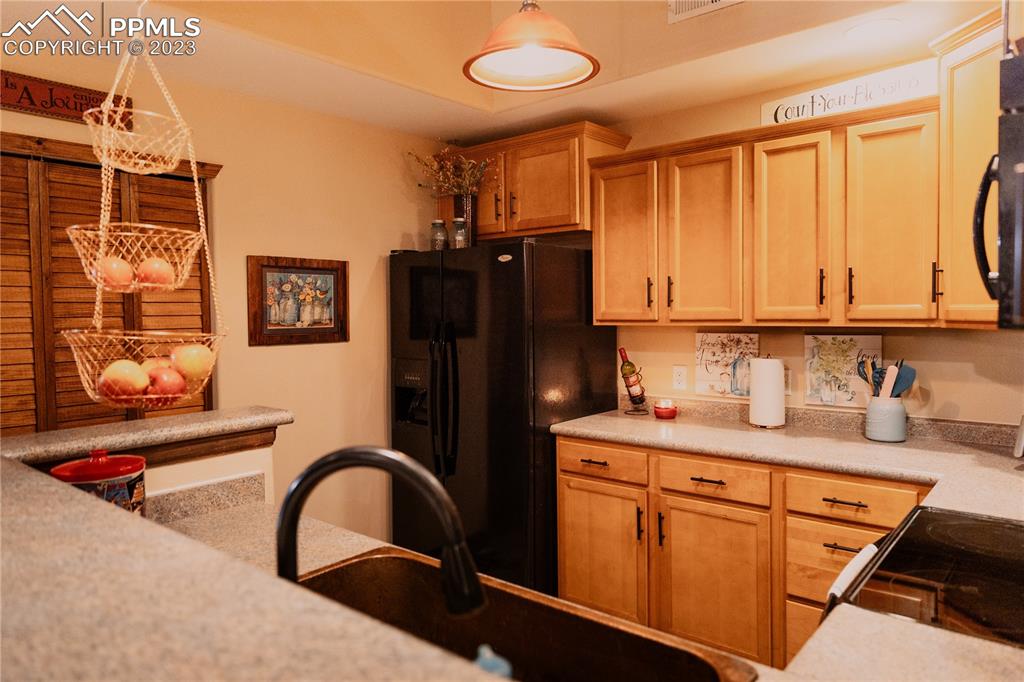 4848 Kerry Lynn View, Unit 202 Colorado Springs, CO 80922 - Photo 8 of 14 a kitchen with stainless steel appliances granite countertop a refrigerator sink and cabinets