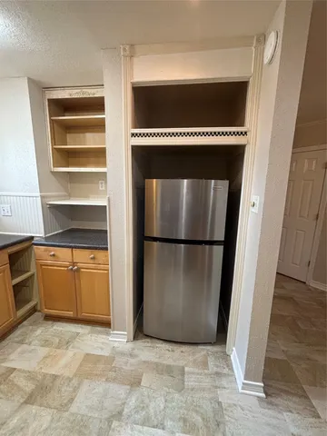 a kitchen with a refrigerator and cabinets