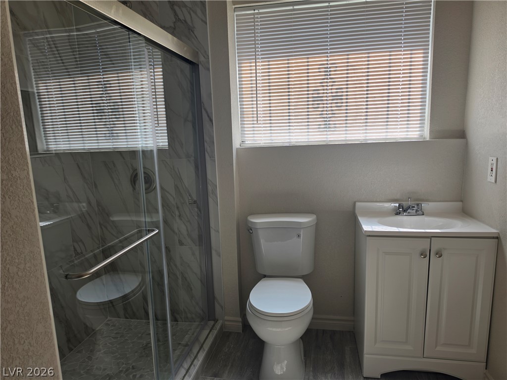 5289 Reeder Circle Las Vegas, NV 89119 - Photo 32 of 40 Modern stone tile accents the walk-in glass shower next to a classic white vanity.