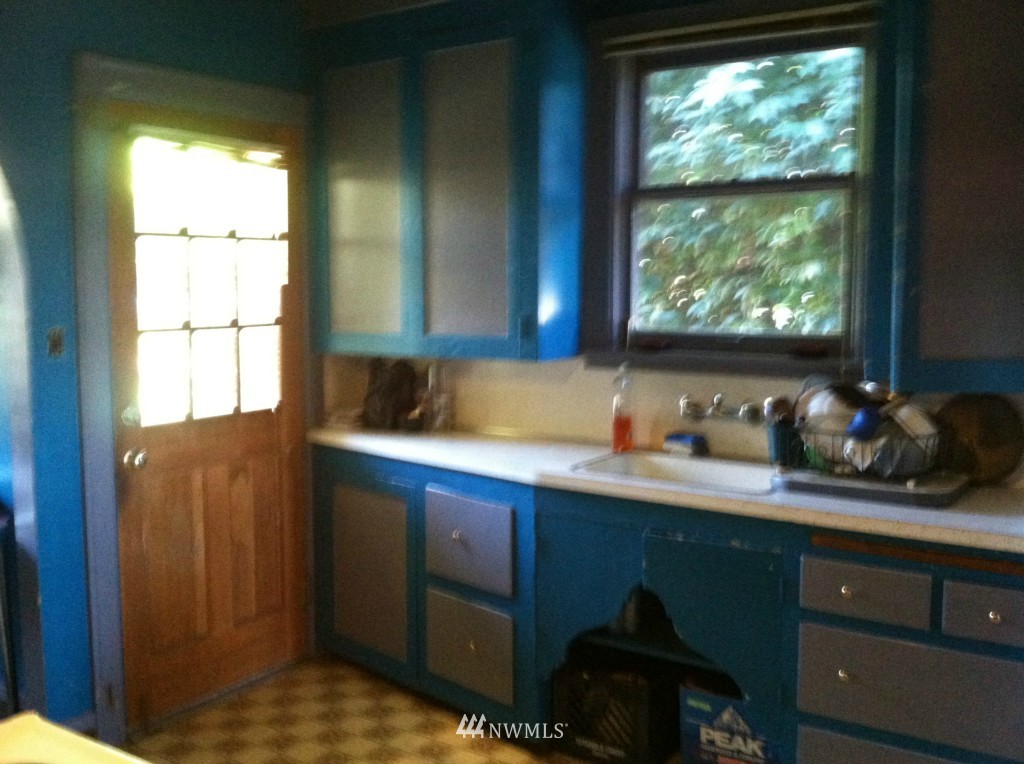816 North 46th Street Seattle, WA 98103 - Photo 18 of 21 a kitchen with kitchen island a window a sink and a counter