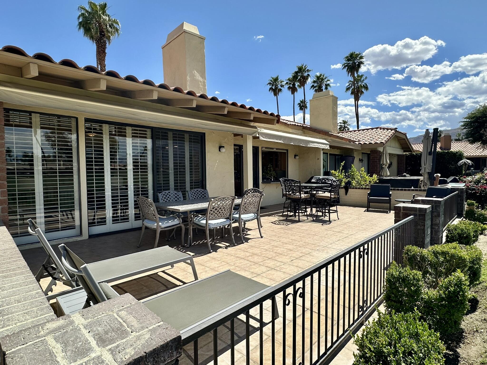 264 Ave Del Sol Palm Desert, CA 92260 - Photo 4 of 15 a view of a patio with table and chairs potted plants and a large tree