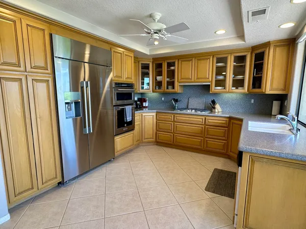 a kitchen with stainless steel appliances granite countertop a refrigerator and a sink