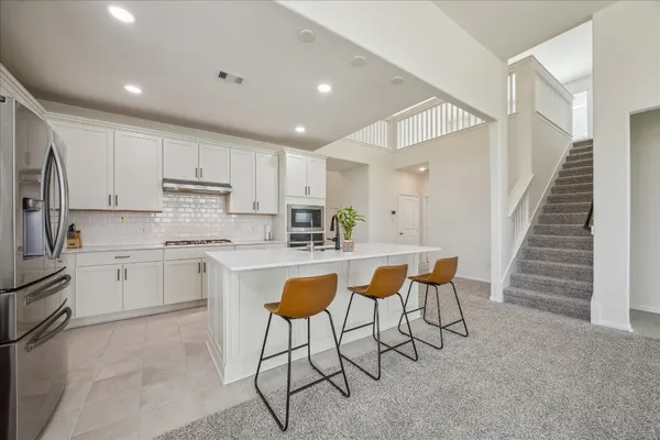a kitchen with stainless steel appliances granite countertop a sink and cabinets