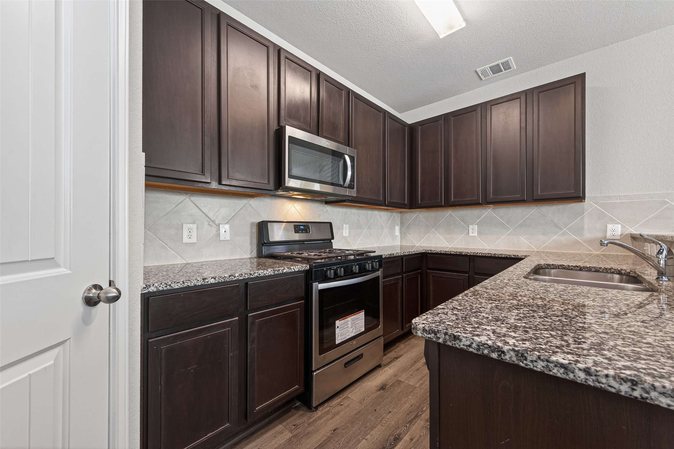 23646 Buttress Root Drive Spring, TX 77373 - Photo 3 of 9 a kitchen with stainless steel appliances granite countertop wooden cabinets a stove top oven a sink and dishwasher