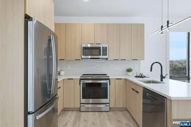 a kitchen with stainless steel appliances granite countertop a refrigerator and a stove top oven