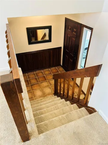 a view of an empty room with wooden floor and a rug