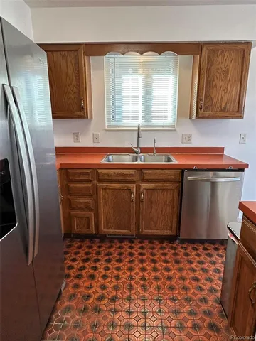 a kitchen with a sink a refrigerator and cabinets