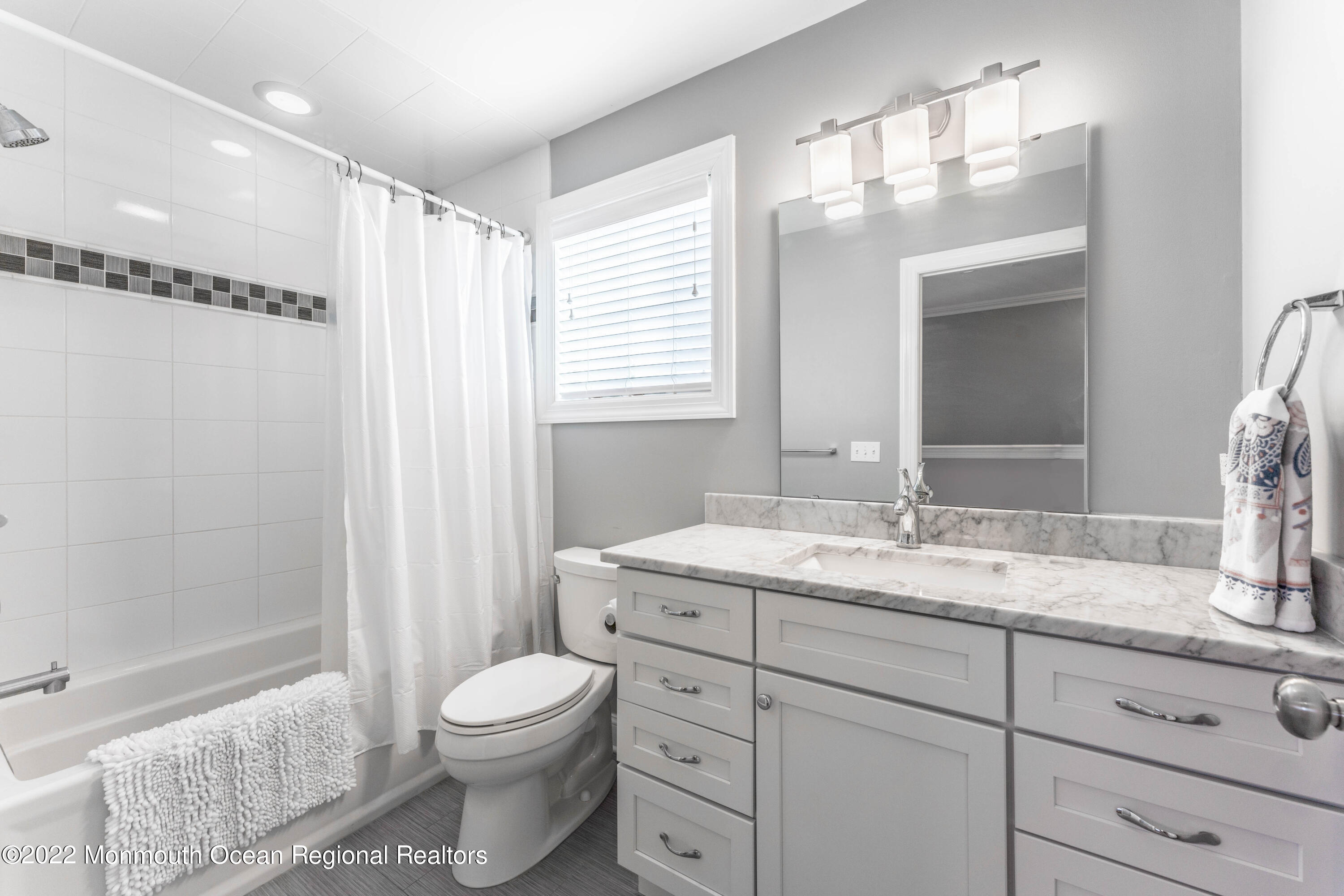 544 Brielle Road Manasquan, NJ 08736 - Photo 16 of 20 a bathroom with a granite countertop sink toilet a mirror a vanity and shower