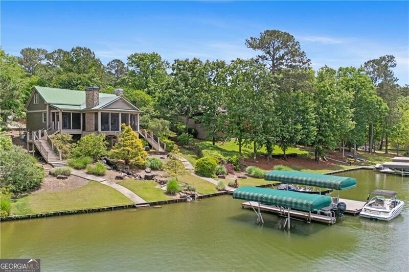 1041 Fox Chase Run Greensboro, GA 30642 - Photo 1 of 45 an aerial view of a house with swimming pool patio and lake view