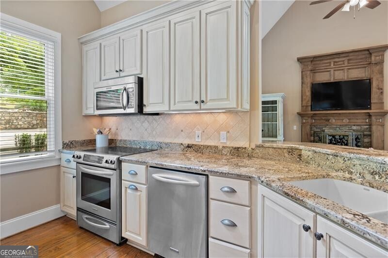1041 Fox Chase Run Greensboro, GA 30642 - Photo 28 of 45 a kitchen with granite countertop a sink stove and cabinets