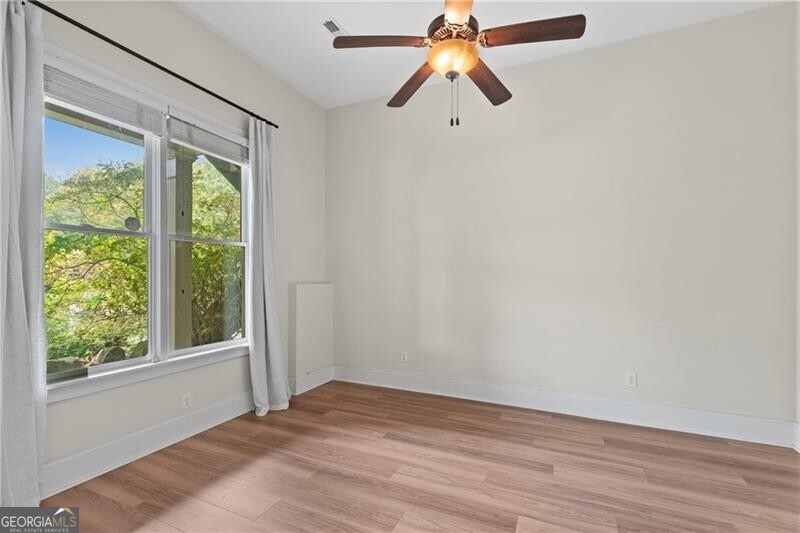 1041 Fox Chase Run Greensboro, GA 30642 - Photo 44 of 45 an empty room with wooden floor fan and windows