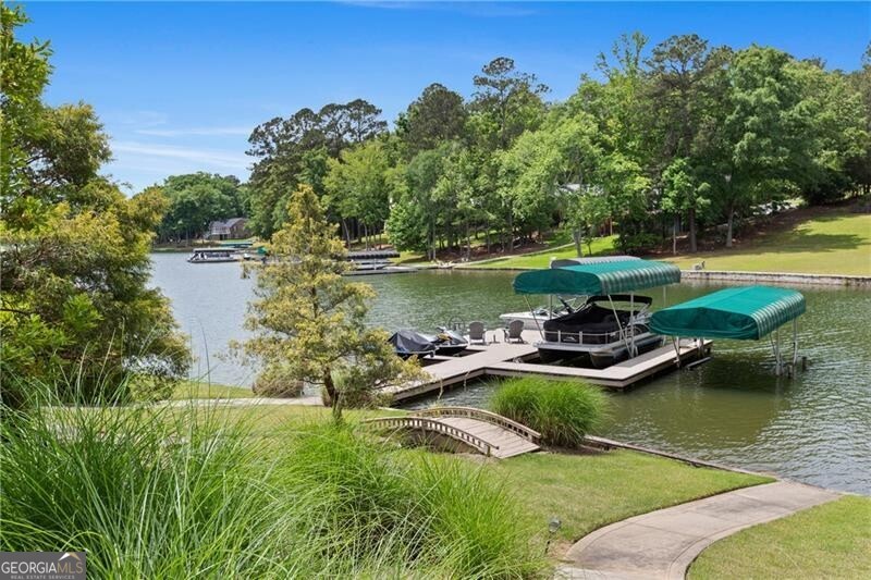 1041 Fox Chase Run Greensboro, GA 30642 - Photo 10 of 45 a view of a lake with lawn chairs and large trees