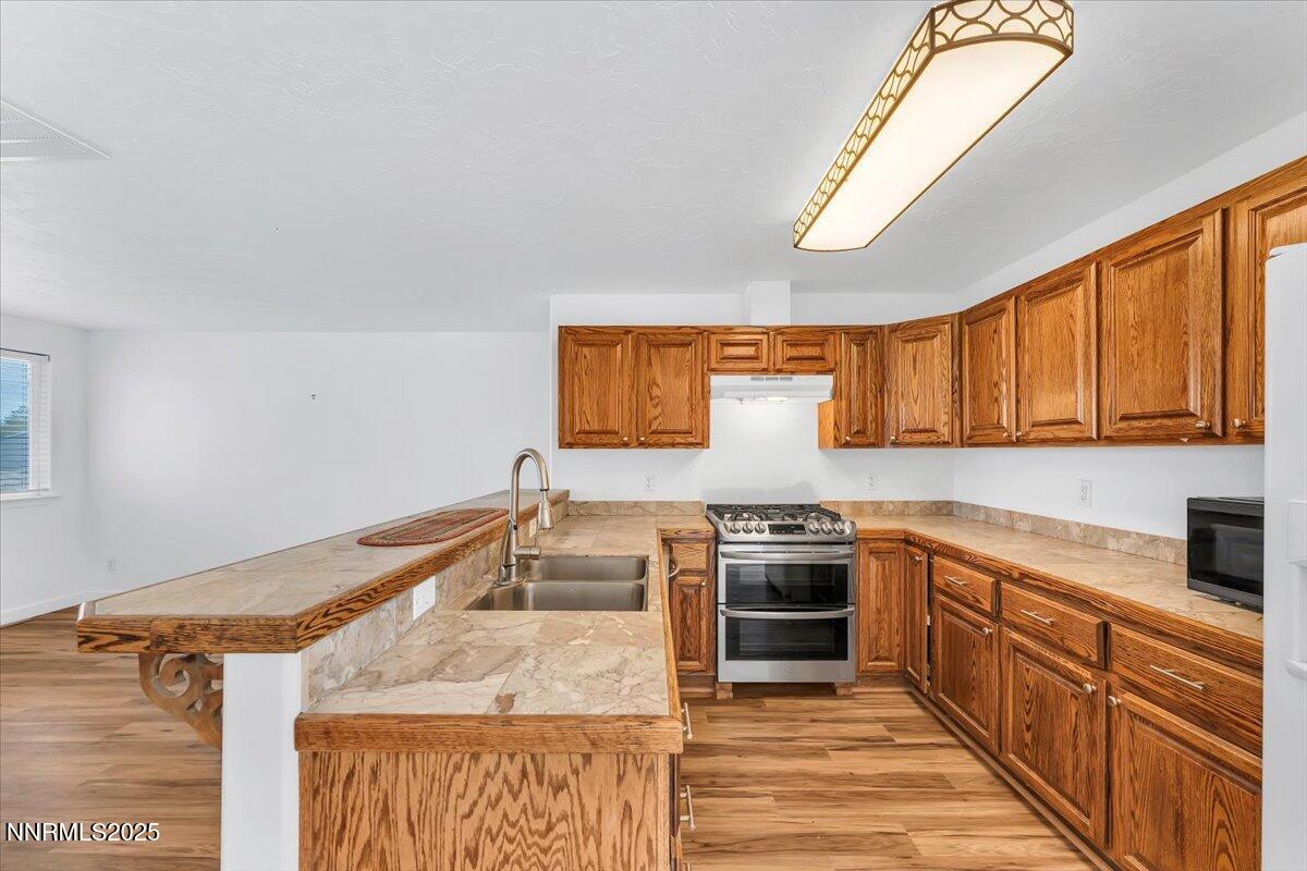 988 Bench Road Fallon, NV 89406 - Photo 11 of 54 a kitchen with stainless steel appliances granite countertop a stove a sink and a refrigerator