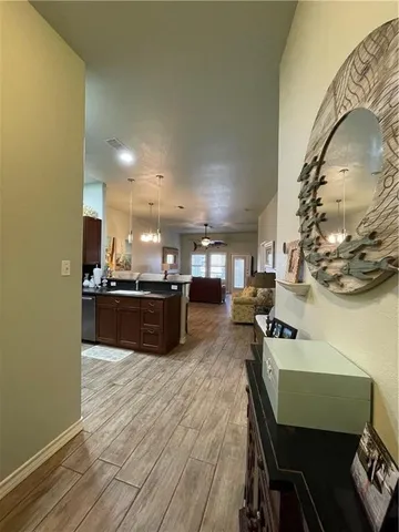 a kitchen with a sink dishwasher a dining table and chairs with wooden floor