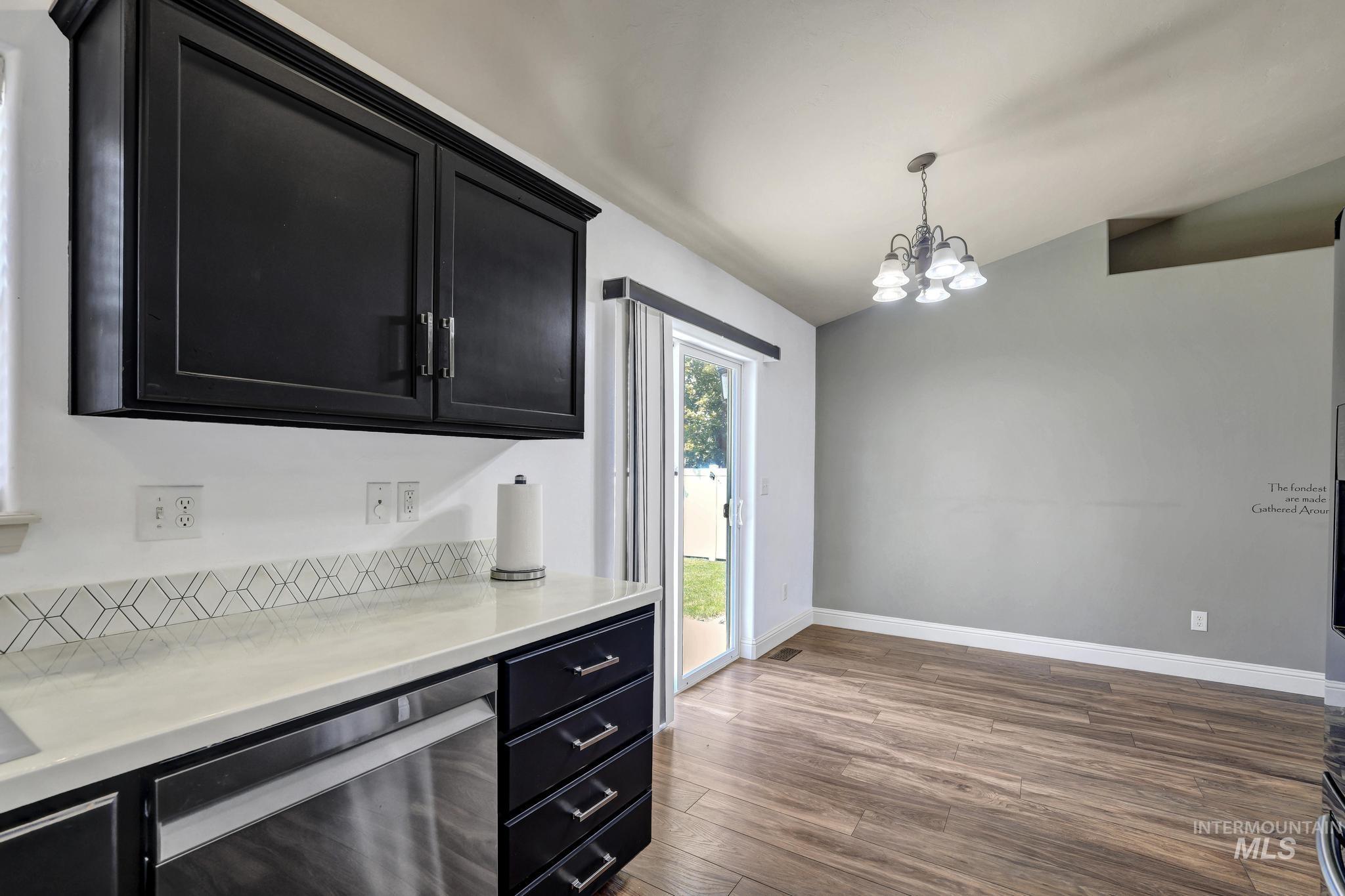446 Noble Street Twin Falls, ID 83301 - Photo 11 of 42 Kitchen area featuring dark cabinetry, stainless steel dishwasher, light-toned countertop, and a geometric tile backsplash