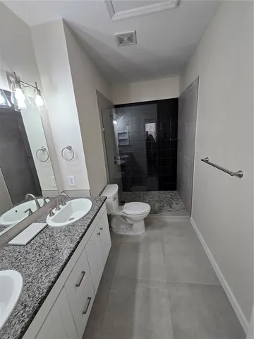 a bathroom with a sink a toilet a mirror and vanity