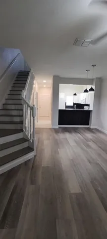 a view of an empty room with wooden floor