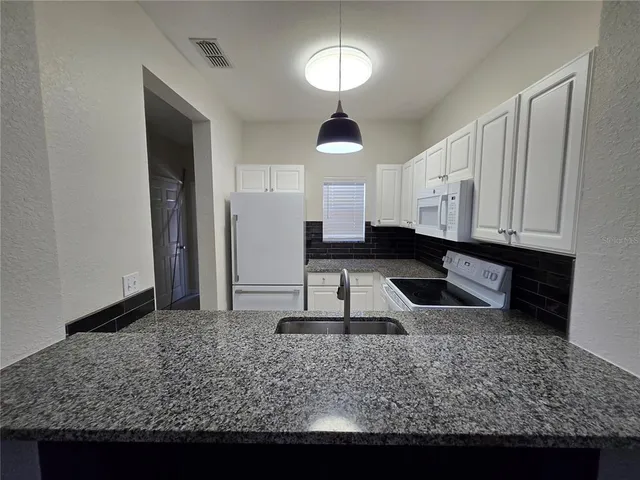 a kitchen with sink and refrigerator