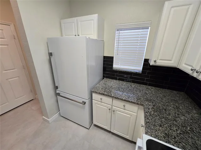 a kitchen with white cabinets and white appliances