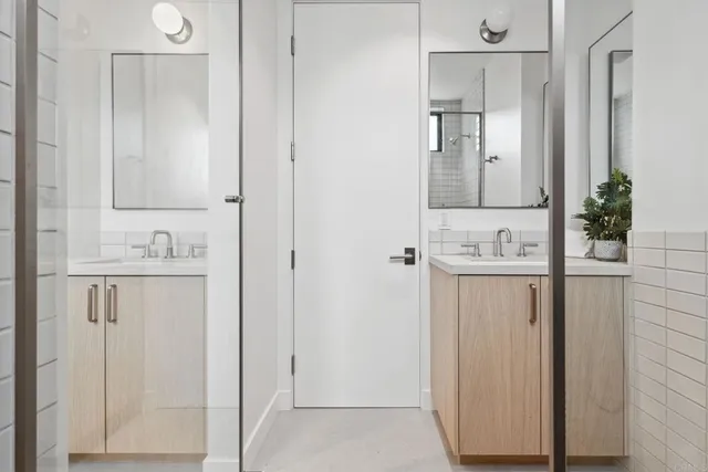 a bathroom with a sink and mirror with shower
