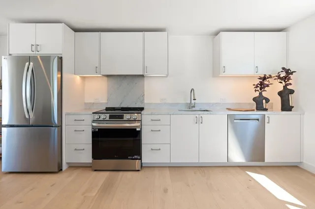 a bathroom with a granite countertop sink a mirror a shower and a toilet