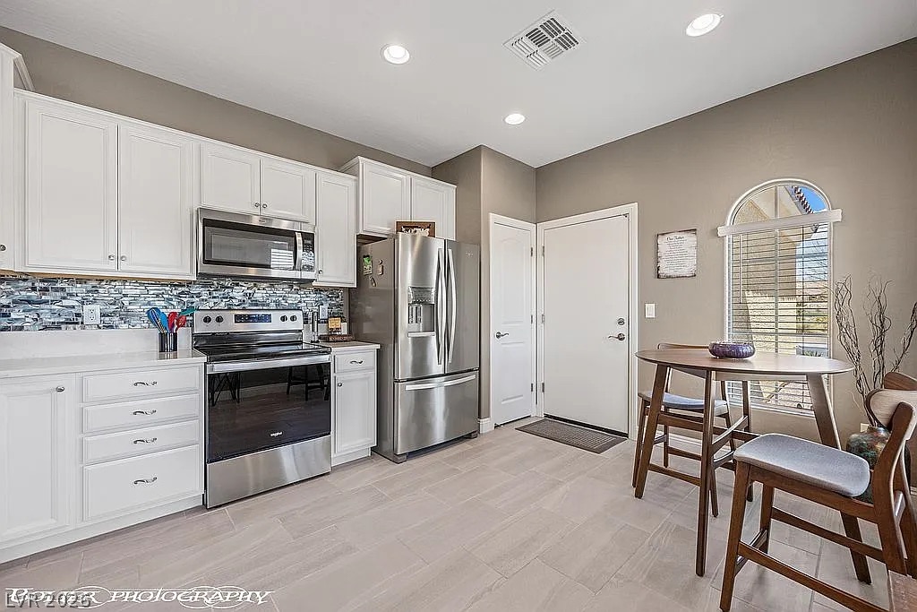 1304 Cottage Ridge Mesquite, NV 89034 - Photo 8 of 52 Culinary delights await in this bright kitchen, complete with a dining area and modern stainless steel appliances.