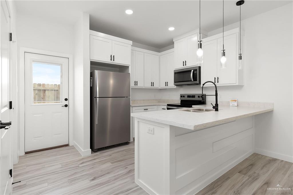 518 East E Loop, Unit 7 Harlingen, TX 78550 - Photo 5 of 14 a kitchen with stainless steel appliances a refrigerator sink and microwave