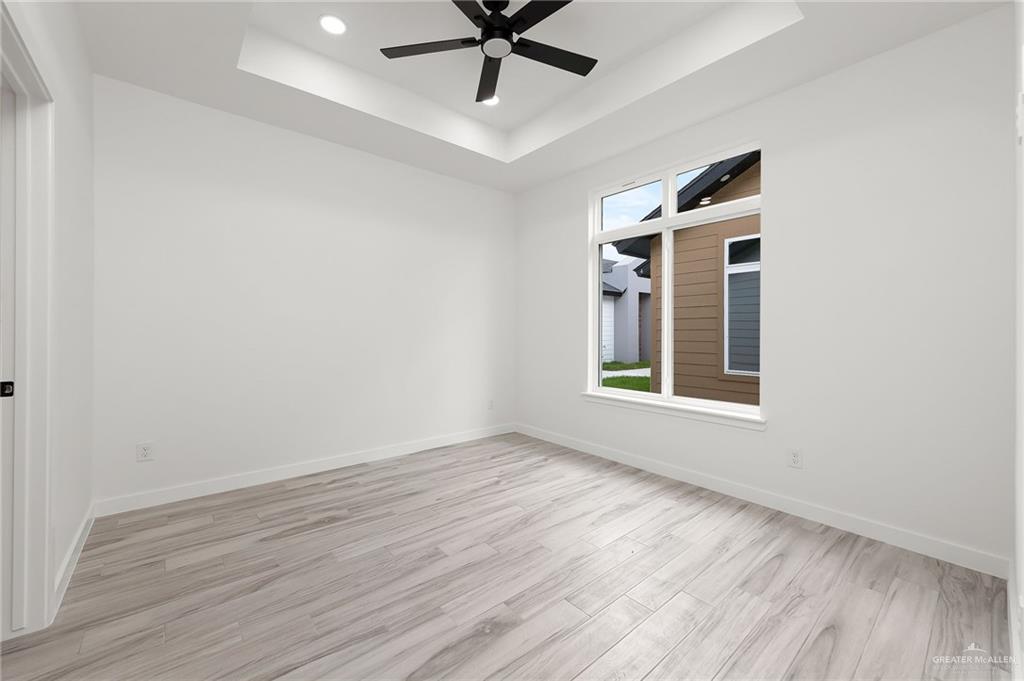 518 East E Loop, Unit 7 Harlingen, TX 78550 - Photo 10 of 14 wooden floor in an empty room with a window