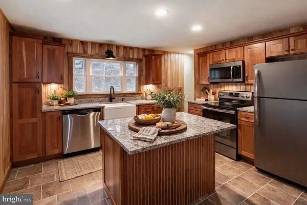 a kitchen with stainless steel appliances granite countertop a sink stove refrigerator and a window
