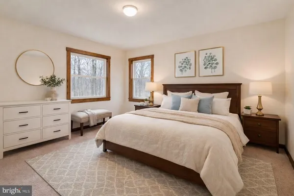 a bedroom with a bed mirror on wall and a window