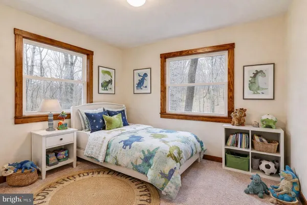 a bedroom with a bed a dresser and a window