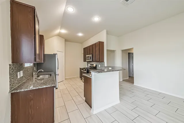 a kitchen with a sink refrigerator and microwave
