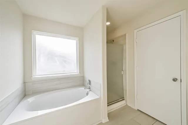 a white bath tub sitting next to a shower