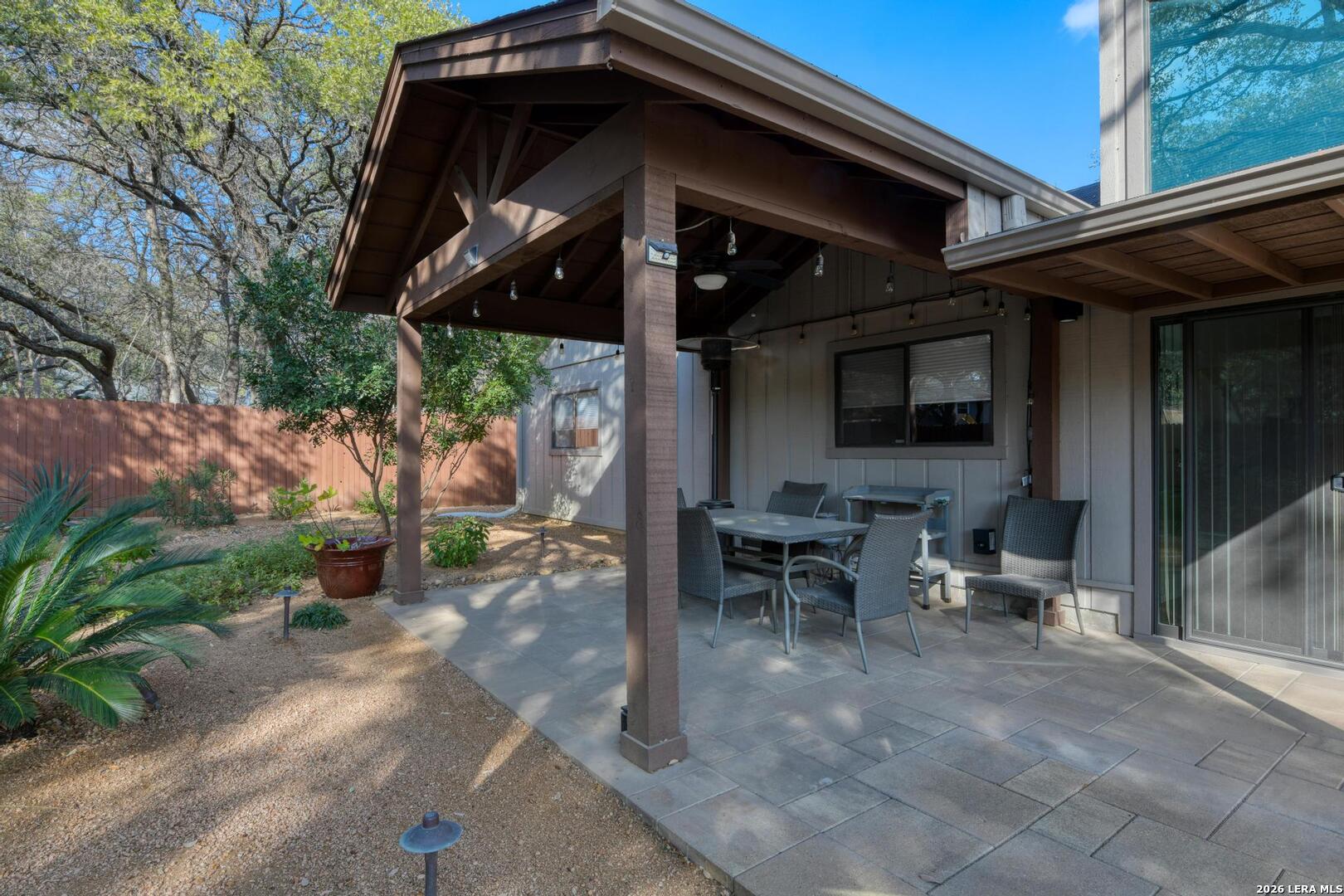 3154 Morning Trail San Antonio, TX 78247 - Photo 15 of 41 a view of a patio with table and chairs under an umbrella with a fire pit