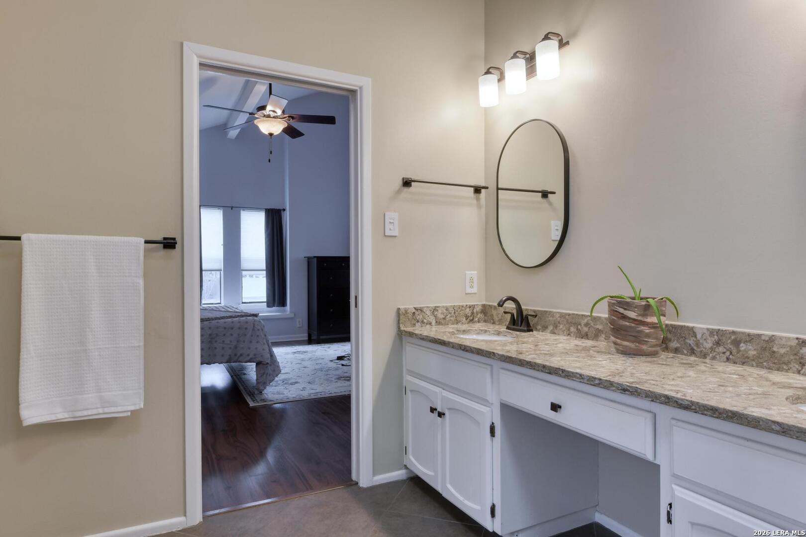 3154 Morning Trail San Antonio, TX 78247 - Photo 32 of 41 a en suite bathroom with a granite countertop sink and a mirror