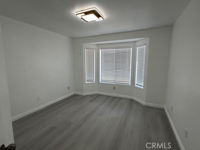 4679 Gorgonio Road Phelan, CA 92371 - Photo 14 of 17 an empty room with wooden floor and windows