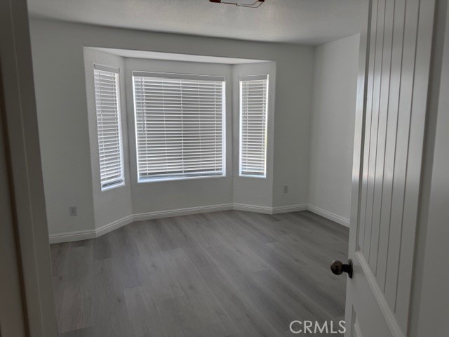 4679 Gorgonio Road Phelan, CA 92371 - Photo 15 of 17 a view of an empty room with wooden floor and a window
