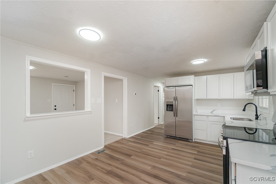 19256 Perimeter Road Milford, VA 22514 - Photo 11 of 29 Kitchen with hardwood / wood-style floors, white c