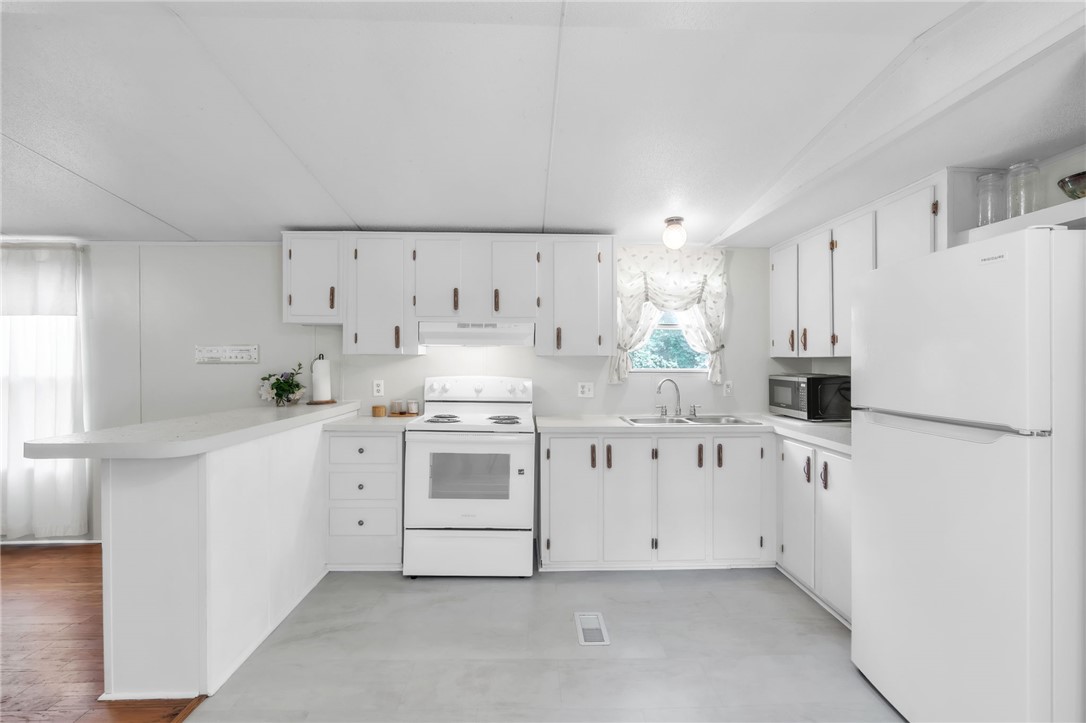 506 Charlies Creek Road Iva, SC 29655 - Photo 11 of 28 Bright, practical kitchen space features white cabinetry and modern appliances, perfect for daily meal preparation.