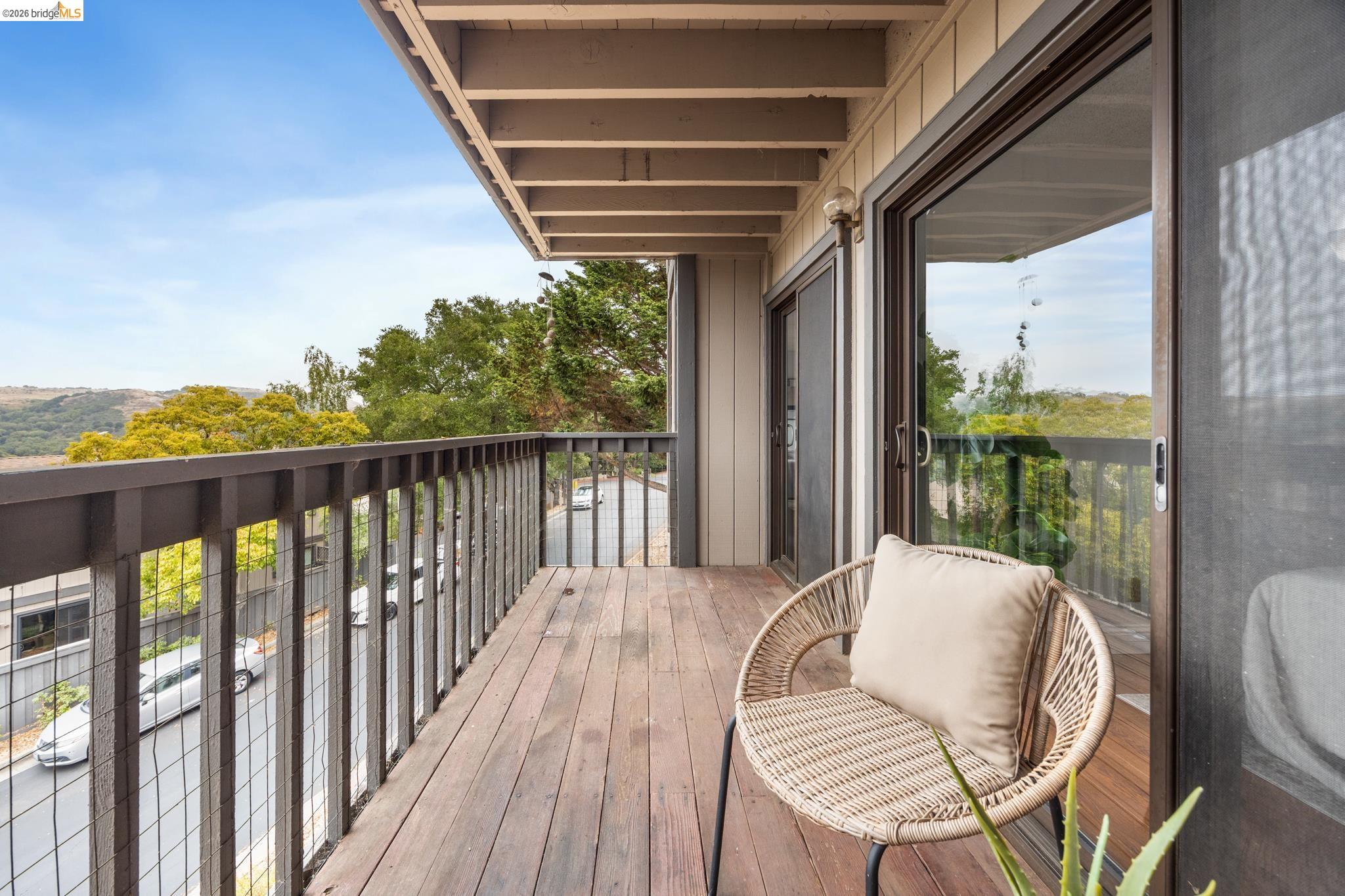 201 Vista Heights Road El Cerrito, CA 94530 - Photo 14 of 32 Outdoor balcony featuring wood-finish decking, dark wood railing with wire infill, and a sliding glass door