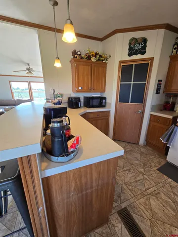 a kitchen with stainless steel appliances a stove a refrigerator a sink a couch and wooden floor