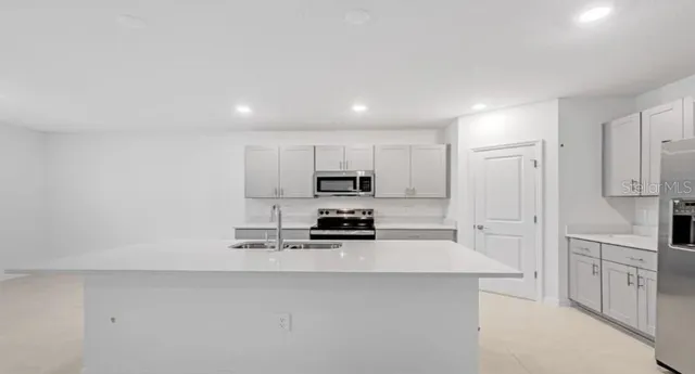 a kitchen with white cabinets and stainless steel appliances