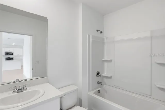 a view of a kitchen with white cabinets