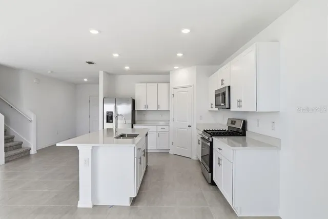 a kitchen with stainless steel appliances kitchen island granite countertop a sink and cabinets