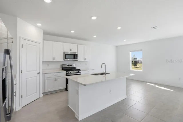 a kitchen with stainless steel appliances granite countertop a sink and a stove