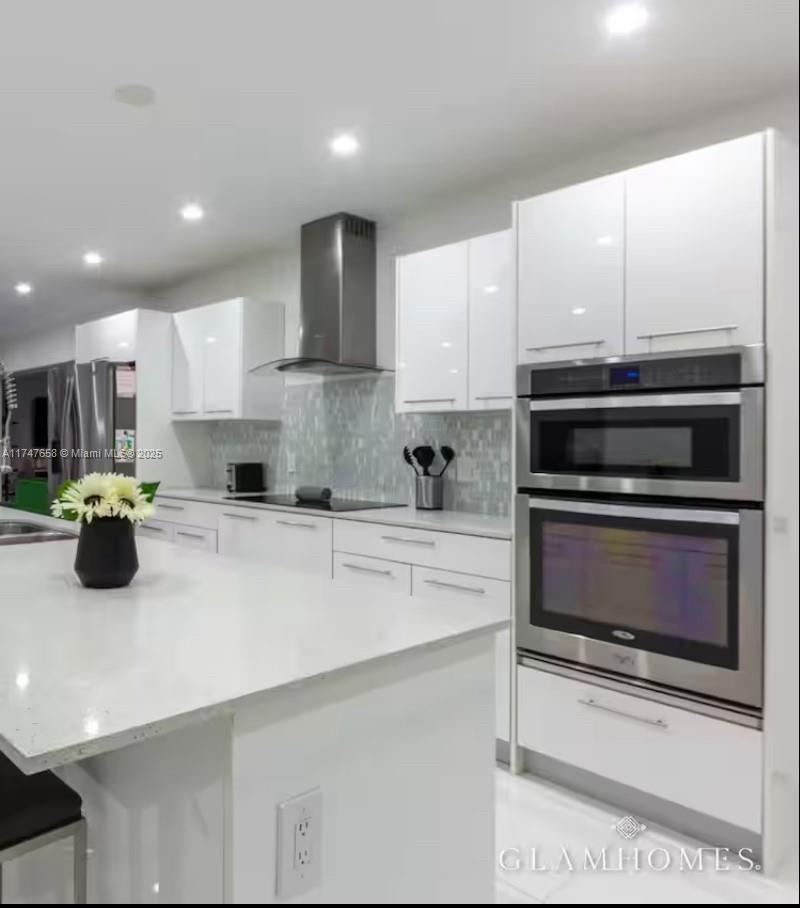 2271 Northeast 191st Street Miami, FL 33180 - Photo 14 of 24 a kitchen with stainless steel appliances a stove a sink and a microwave