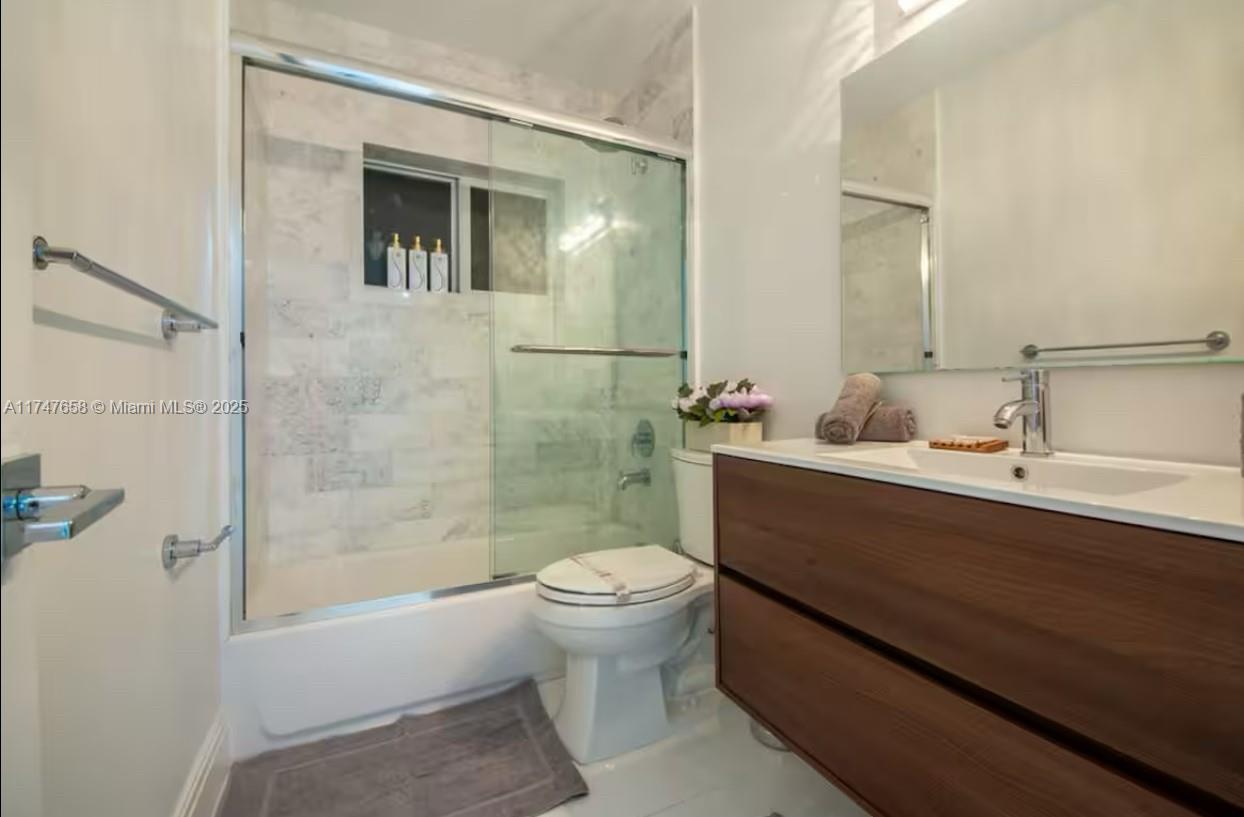 2271 Northeast 191st Street Miami, FL 33180 - Photo 22 of 24 a bathroom with a sink a toilet and shower