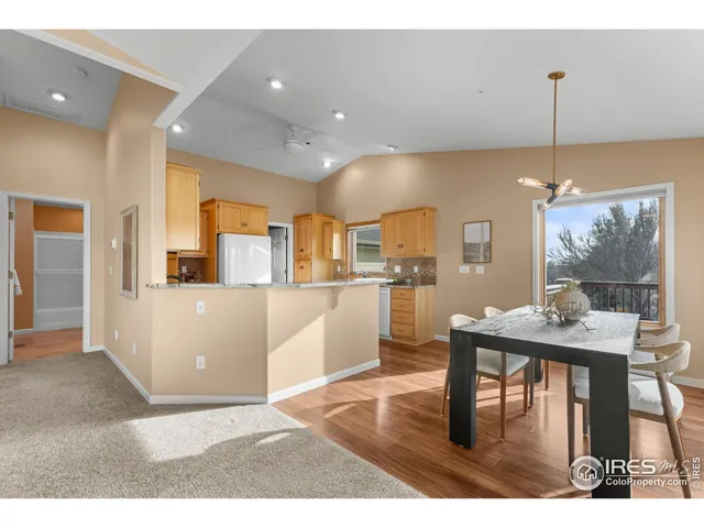 a living room with kitchen island furniture wooden floor and a chandelier